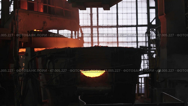 The Industrial Metal Melting Process in foundries creates metallic ingots using advanced techniques. Стоковое фото, фотограф David Kashakhi / Фотобанк Лори