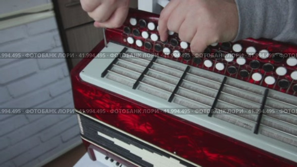 The man fasten with screws the right cover of the button accordion. Using a screwdriver. Bayan repair and maintenance. Стоковое видео, видеограф Vadzim Yakubovich / Фотобанк Лори
