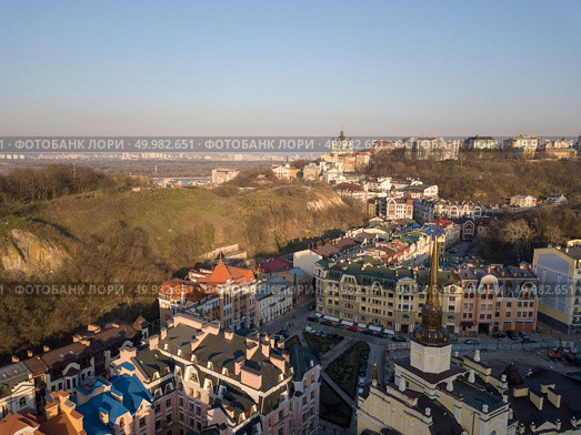 The modern area of Vozdvizhenka on Podil in the city of Kiev next to the Bald Mountain, in the distance Andreevskaya church. Ukraine. Drone photograph. District Vozdvizhenka on Podol with modern houses and a bald mountain, the city of Kiev Ukraine. Стоковое фото, агентство Ingram Publishing / Фотобанк Лори