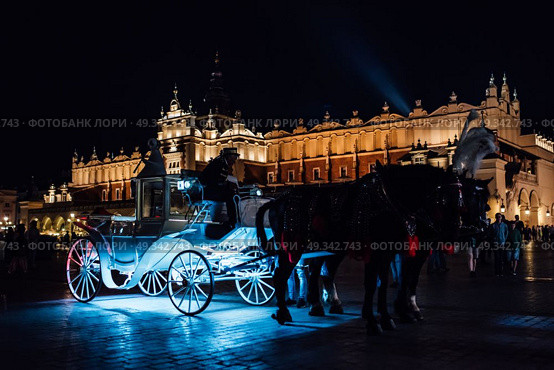 The old square of the night krakow with luminous horse-drawn carriages. Стоковое фото, агентство Ingram Publishing / Фотобанк Лори