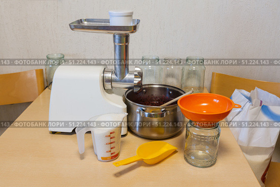 The process of making jam. The berries are ground in a meat grinder and mixed with sugar. Sugar is measured out with a measuring cup. Preparing vitamins for the winter. Стоковое фото, фотограф Виктория Катьянова / Фотобанк Лори