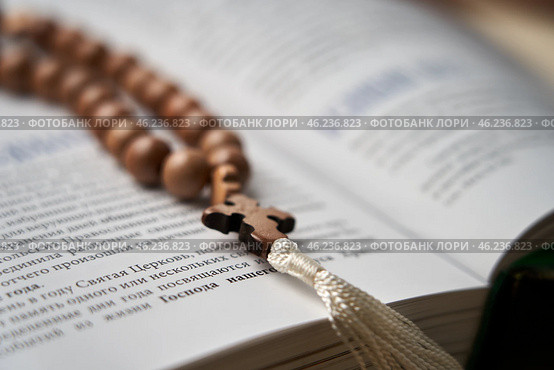 The rosary in the open Bible inspire prayer and reflection on the Word of God. Стоковое фото, фотограф Скрипачев Антон / Фотобанк Лори