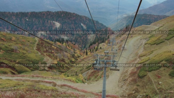 The ski lift, which tourists use to reach the peaks, offers a spectacular autumn landscape. Осенний пейзаж, снятый с горнолыжного подъемника, которым туристы пользуются, чтобы подняться на вершины. Редакционное видео, видеограф Валерий Тесаков / Фотобанк Лори