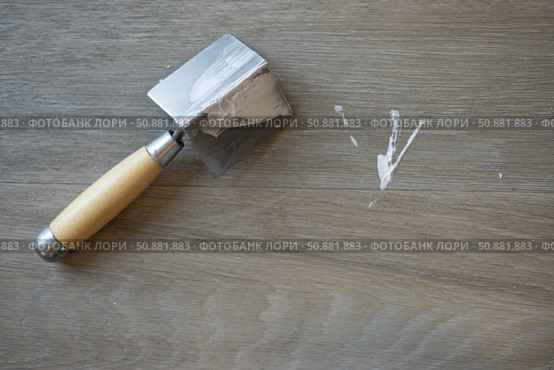 The spatula for the corners. Laminated grey background. Repair concept, repair goods stores. Top down view. Copy space. Стоковое фото, фотограф Екатерина Топорова / Фотобанк Лори