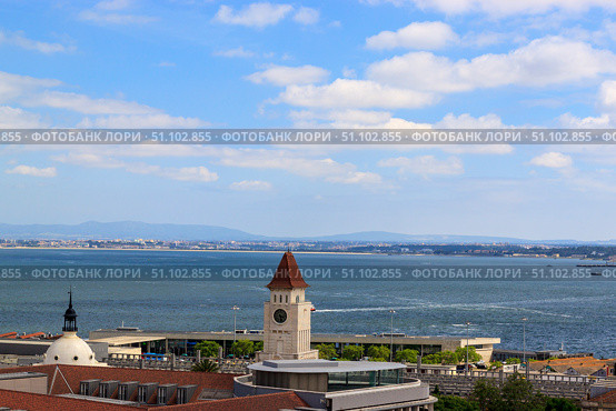 The view of the city from view point on a sunny summer day. The roofs of the houses and the river Tagus. Lisbon, Portugal. Стоковое фото, фотограф Вера Федорова / Фотобанк Лори