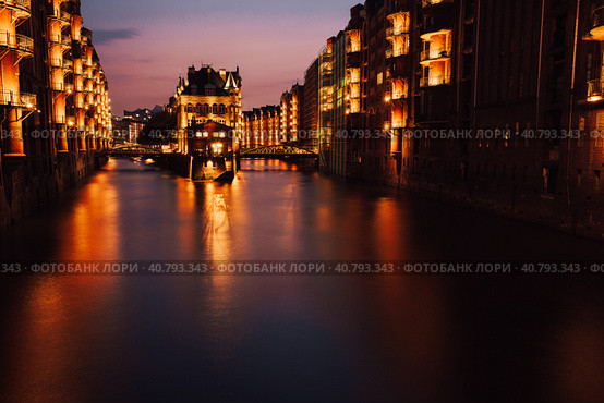 The Warehouse District - Speicherstadt in twilight. Tourism landmark of Hamburg. View of Wandrahmsfleet in light of lantern lamp. Port of Hamburg within the HafenCity quarter (2018 год). Стоковое фото, фотограф Igor Tichonow / Фотобанк Лори