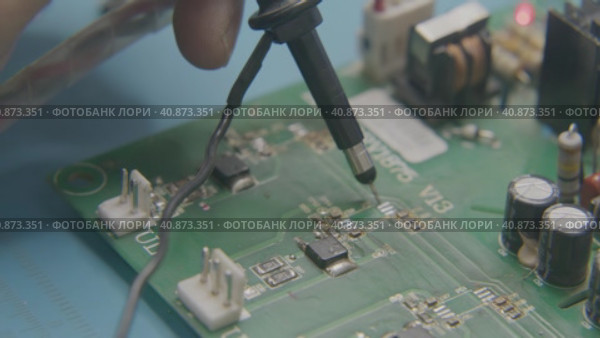 The wizard uses an electronic tester to test the components on the computer board. Стоковое видео, видеограф Aleksey Kidisyuk / Фотобанк Лори