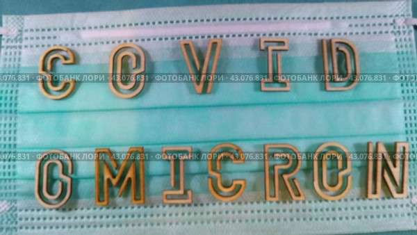 The word covid variant omicron in wooden letters on the face mask. Стоковое видео, видеограф Variyy / Фотобанк Лори