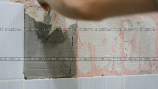 The worker removes the old ceramic tile from the wall in the bathroom. Стоковое видео, видеограф Андрей Радченко / Фотобанк Лори