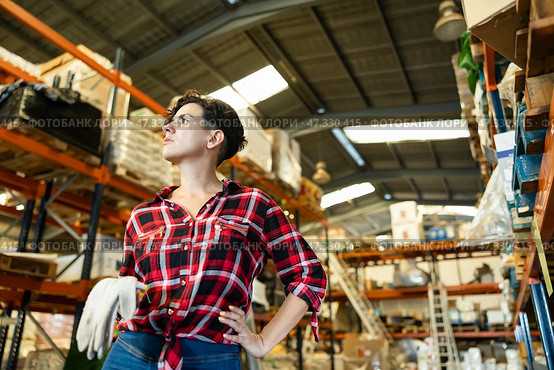 Thoughtful female storekeeper looking for tedious goods in building materials warehouse indoor. Стоковое фото, фотограф Яков Филимонов / Фотобанк Лори