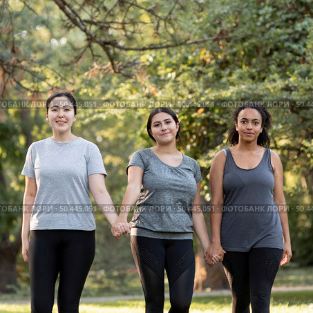 three female friends holding hands park. Стоковое фото, агентство Ingram Publishing / Фотобанк Лори