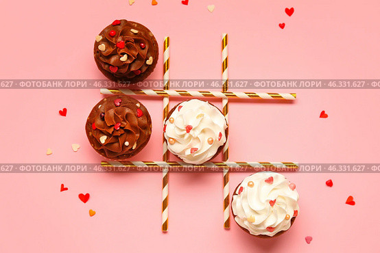 Tic tac toe game with tasty cupcakes and straws for Valentine's Day on pink background. Стоковое фото, фотограф Pixel_shot / Фотобанк Лори