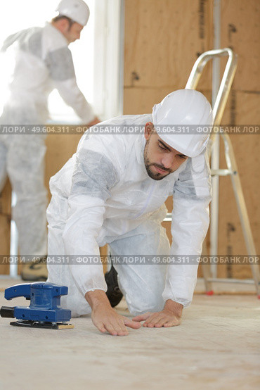 tile installer inspecting the flooring. Стоковое фото, агентство Ingram Publishing / Фотобанк Лори