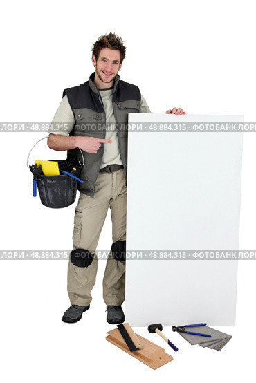 Tiler pointing at blank advertising panel. Стоковое фото, агентство Ingram Publishing / Фотобанк Лори