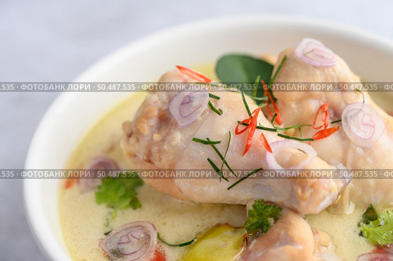 Tom Kha Kai in a bowl with kaffir lime leaves, lemongrass, red onion, galangal and chilli.Selective focus. Стоковое фото, агентство Ingram Publishing / Фотобанк Лори