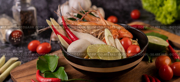 Tom Yum Kung in a bowl with tomato, chili, lemongrass, garlic, lemon, and kaffir lime leaves. Стоковое фото, агентство Ingram Publishing / Фотобанк Лори