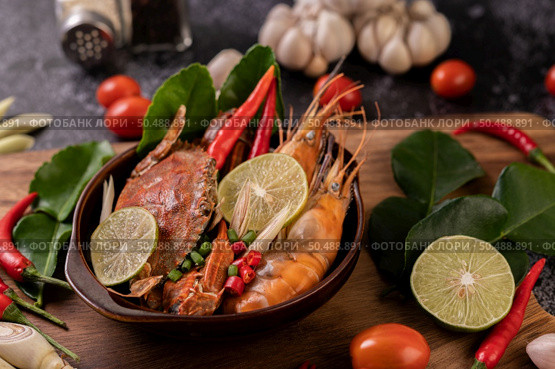 Tom Yum Kung in a bowl with tomato, chili, lemongrass, garlic, lemon, and kaffir lime leaves. Стоковое фото, агентство Ingram Publishing / Фотобанк Лори