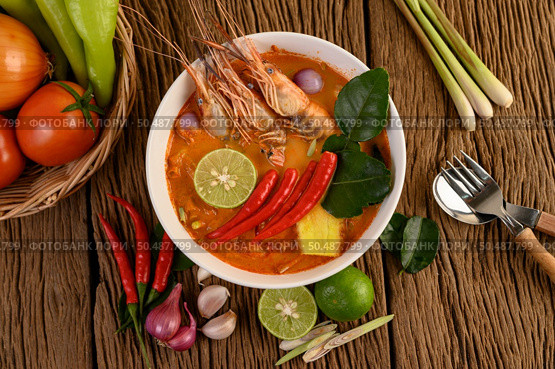 Tom Yum Kung Thai hot spicy soup shrimp with lemon grass,lemon,galangal and chilli on wooden background Thailand Food. Стоковое фото, агентство Ingram Publishing / Фотобанк Лори