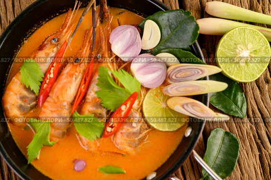 Tom Yum Kung Thai hot spicy soup shrimp with lemon grass,lemon,galangal and chilli on wooden background Thailand Food. Стоковое фото, агентство Ingram Publishing / Фотобанк Лори