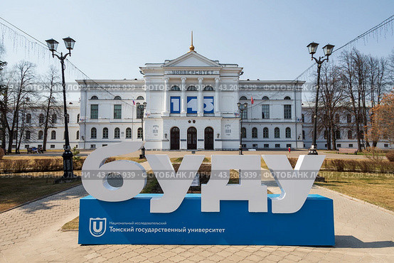 Томский государственный университет, город Томск, Томская область, Сибирь, Россия. Большая надпись «буду» перед главным зданием Томского государственного университета. На фасаде по бокам от входа надписи «Основан в 1878 году», «Открыт в 1888 году». Высшее образование в России. (2023 год). Редакционное фото, фотограф Андрей Степанов / Фотобанк Лори