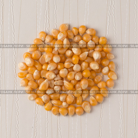 Top view of circle of corn against beige vinyl background. Стоковое фото, агентство Ingram Publishing / Фотобанк Лори