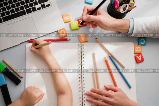 Top view of desk with child being tutored. Стоковое фото, агентство Ingram Publishing / Фотобанк Лори