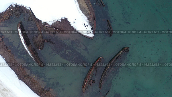 Top view of many old wrecked ships drowned at the sea shore in snowy winter season. Стоковое фото, фотограф David Kashakhi / Фотобанк Лори