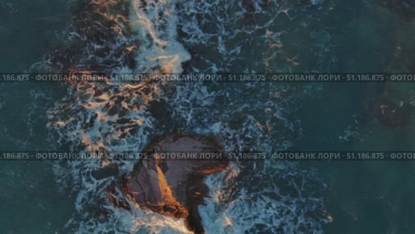 Top view of waves and rocks in sea. Стоковое видео, видеограф Михаил Коханчиков / Фотобанк Лори