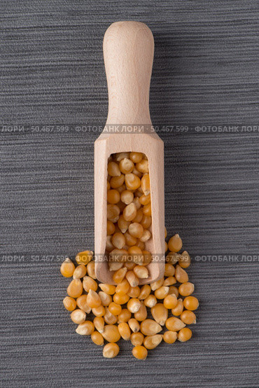 Top view of wooden scoop with corn against grey vinyl background. Стоковое фото, агентство Ingram Publishing / Фотобанк Лори