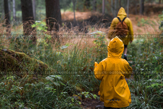 Tourism. Hiking. Ladoga skerries. Father and son tourists in yellow raincoats on stone islands in the forest. Republic of Karelia, Russia. Стоковое фото, фотограф Photojuli / Фотобанк Лори