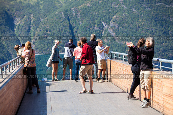 Tourists enjoy fjord view Aurlandsfjord landscape from Stegastein viewing point. Aurlandsfjellet. Norway (2018 год). Редакционное фото, фотограф Кекяляйнен Андрей / Фотобанк Лори