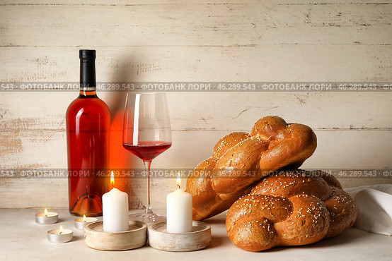 Traditional challah bread with wine and glowing candles on white wooden background. Shabbat Shalom. Стоковое фото, фотограф Pixel_shot / Фотобанк Лори