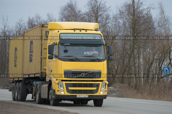 Трак VOLVO FH 13 440 с полуприцепом-контейнеровозом на шоссе сумрачным мартовским днем (2017 год). Редакционное фото, фотограф Виктор Карасев / Фотобанк Лори