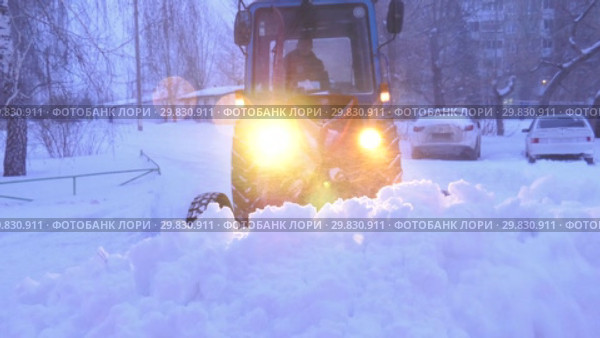 Трактор убирает снег с проезжей части. Tractor removes snow from the roadway. (2019 год). Стоковое видео, видеограф Евгений Романов / Фотобанк Лори