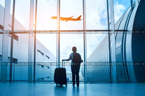travel concept, woman in airport, passenger silhouette waiting with luggage in airport. Стоковое фото, агентство Ingram Publishing / Фотобанк Лори
