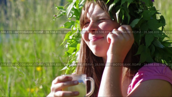 Травяной чай. Молодая девушка пьёт травяной чай на лугу. Herbal tea. A young girl is drinking herbal tea in the meadow. Стоковое видео, видеограф Евгений Романов / Фотобанк Лори