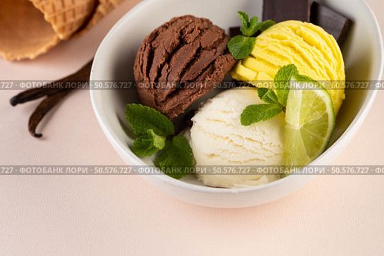 Trio of tasty chocolate vanilla and strawberry flavored frozen dessert in a blue bowl with two wafer straws. Trio of tasty chocolate vanilla and lime flavored frozen dessert in a white bowl. Стоковое фото, агентство Ingram Publishing / Фотобанк Лори
