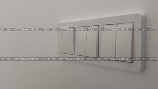Triple switch on wall in house. Woman turns on light in apartment by pressing button with her finger. Concept of energy saving and economy. On and Off Light in room. Стоковое видео, видеограф Ирина / Фотобанк Лори