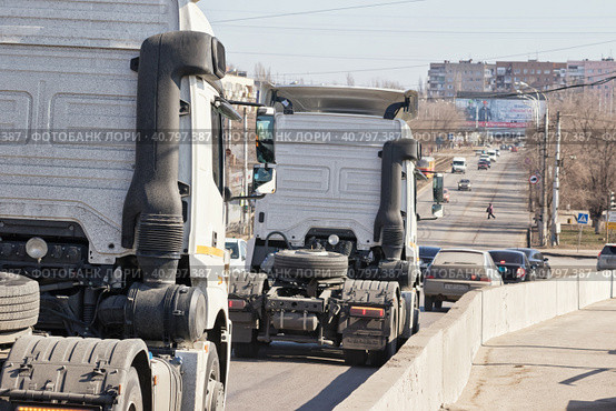Trucks tractors without trailers down from the bridge into the stream of urban transport (2017 год). Редакционное фото, фотограф Сергей Сергеев / Фотобанк Лори
