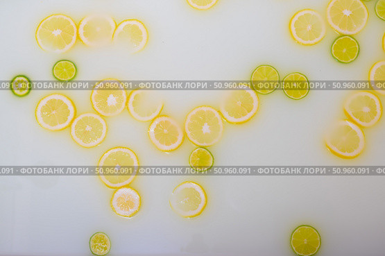 Turbid soapy water in the bath with slices of lemon and lime top view in full frame. Citrus. Spa with milk in the bath for rejuvenation. Стоковое фото, фотограф Михаил Решетников / Фотобанк Лори