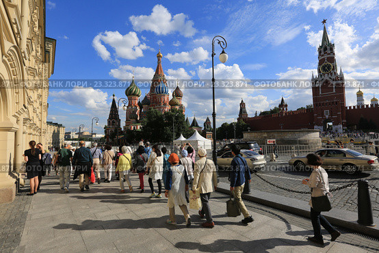 Туристы на Красной площади в Москве на фоне Спасской башни и собора Василия Блаженного (2016 год). Редакционное фото, фотограф Яна Королёва / Фотобанк Лори