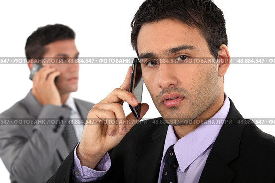 Two businessmen on their mobile telephones. Стоковое фото, агентство Ingram Publishing / Фотобанк Лори