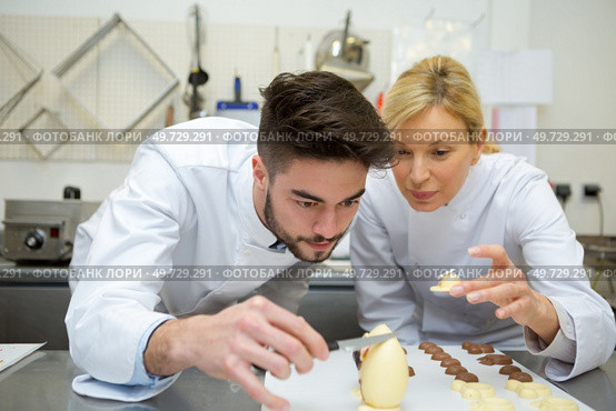 two chefs decorating chocolate egg. Стоковое фото, агентство Ingram Publishing / Фотобанк Лори