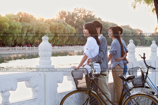Two couples by HouHai Lake with Bicycles in Beijing. Стоковое фото, агентство Ingram Publishing / Фотобанк Лори