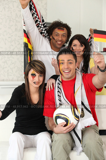 Two couples supporting German football. Стоковое фото, агентство Ingram Publishing / Фотобанк Лори