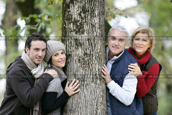 Two generations stood against tree. Стоковое фото, агентство Ingram Publishing / Фотобанк Лори