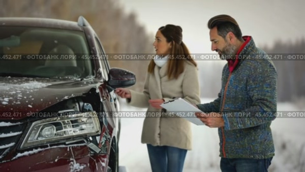 Two individuals assess a car accident in a snowy environment, with a man holding a clipboard next to a damaged car. The scene underscores the importance of car insurance during winter. Стоковое AI-видео, аниматор Igor Tichonow / Фотобанк Лори