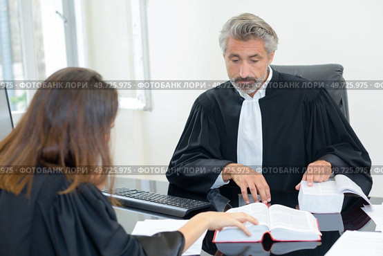 Two legal workers referring to reference book. Стоковое фото, агентство Ingram Publishing / Фотобанк Лори