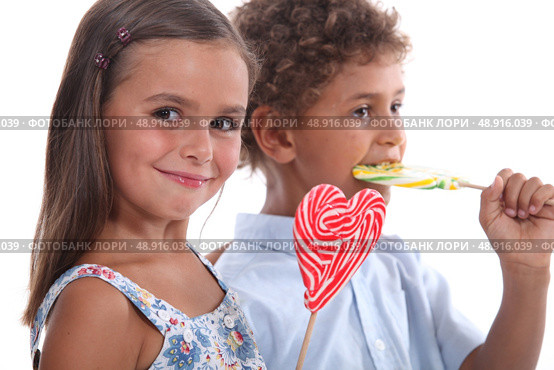 two skittish kids with lollypops. Стоковое фото, агентство Ingram Publishing / Фотобанк Лори