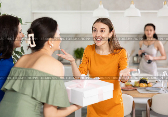Two women have arrived for birthday celebration and presenting gift to birthday woman. Стоковое фото, фотограф Яков Филимонов / Фотобанк Лори